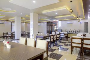 a dining room with tables and chairs in a restaurant at Hotel Pushkar Legacy in Pushkar