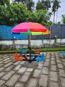 a table with a colorful umbrella and chairs at W Villas in Padinjarathara