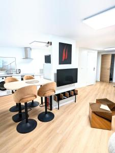 a living room with a table and a tv at Appartement rénové avec parking quartier historique in Bordeaux