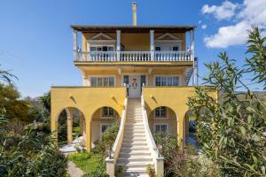 a yellow house with a staircase leading up to it at Katerina's Sunset Apartment in Episkopianá