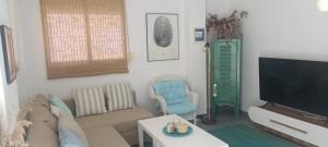 a living room with a couch and a flat screen tv at Luz del Mediterráneo in Moncófar