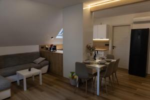 a kitchen and a living room with a table and chairs at Mahne Apartment in Kranj