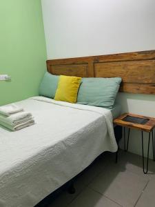 a bed with a wooden headboard and a yellow pillow at El Chirris Tzanjay in San Juan La Laguna