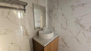 a white bathroom with a sink and a mirror at Bahtera Canggu in Dalung +51 photos