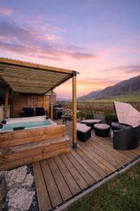 a wooden deck with a hot tub and a pavilion at Juralodgespa Chalet Emma in Courrendlin