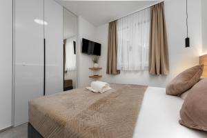 a bedroom with a large bed and a television at Sunshine Breeze in Promajna