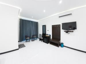 a living room with a tv and a desk at The Grand Moon River Hotel in Kataragama