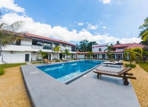 a swimming pool with a bench in front of a building at The Grand Moon River Hotel in Kataragama