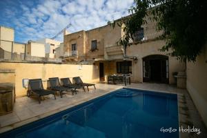 a swimming pool in front of a building at Ta Guzeppi Xaghra in Xagħra