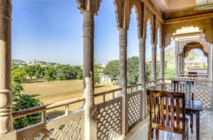 a balcony with a chair and a view of a field at Hotel Pushkar Legacy in Pushkar