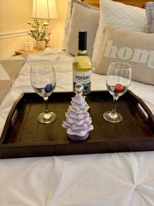 a tray with two wine glasses and a bottle and a christmas tree at Peaceful Oasis steps from Mohegan Sun in Norwich
