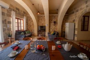 a dining room with a table and a living room at Ta Guzeppi Xaghra in Xagħra