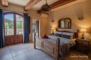 a bedroom with a bed and a large window at Ta Guzeppi Xaghra in Xagħra +30 photos