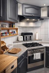 a kitchen with black cabinets and a stove top oven at Juralodgespa Chalet Emma in Courrendlin