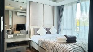 a bedroom with a bed and a tv and a window at 6th Avenue Surin by Win217 in Surin Beach +14 photos