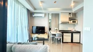 a living room with a kitchen and a dining room at 6th Avenue Surin by Win217 in Surin Beach