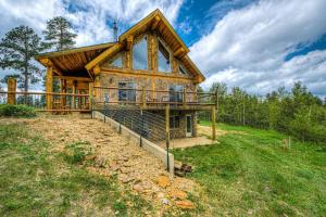 a log cabin with a deck on a hill at Tetro Rock Retreat in Deadwood