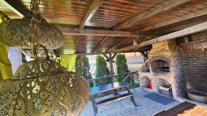 a porch with a bench and a stone fireplace at Casa Stefu in Râşnov