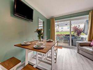 a dining room with a table and a tv at 2 Bed in Swansea oc-90367 in Oxwich