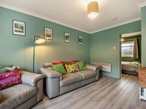 a living room with two couches in a room with green walls at 2 Bed in Swansea oc-90367 in Oxwich