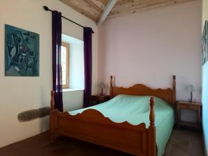 a bedroom with a wooden bed in a room at Aqua Terra Silva in Gravières