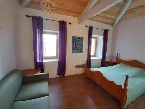 a bedroom with a bed and a couch in a room at Aqua Terra Silva in Gravières