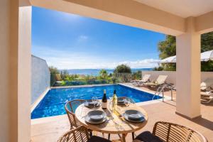 a patio with a table and chairs and a swimming pool at Villa Leo in Barbati