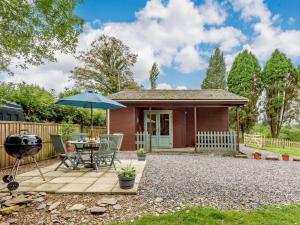 a small house with a picnic table and an umbrella at 2 Bed in Pencader oc-89500 in Pencader