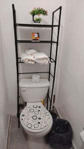 a bathroom with a toilet and a shelf with towels at Central and Comfortable Accommodation 4 in Altamira
