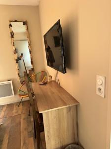 a room with a wooden table with a television on the wall at Hearttoart in Martigues