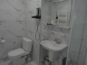 a white bathroom with a toilet and a sink at bayern12 in Tbilisi City +16 photos