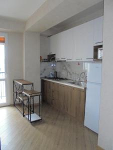 a kitchen with white cabinets and a wooden floor at bayern12 in Tbilisi City