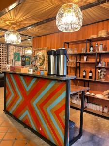 a colorful counter in a restaurant with two chandeliers at RESERVA BOWARA - Ecolodge in Pamplonita