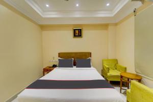 a bedroom with a bed and two chairs at Open Hotel by Olive - Ashok Nagar in Chennai +24 photos