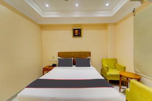 a bedroom with a bed and a yellow chair at Open Hotel by Olive - Ashok Nagar in Chennai