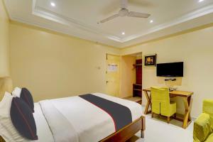 a bedroom with a bed and a desk and a television at Open Hotel by Olive - Ashok Nagar in Chennai