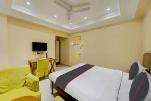 a bedroom with a bed and a desk and a tv at Open Hotel by Olive - Ashok Nagar in Chennai