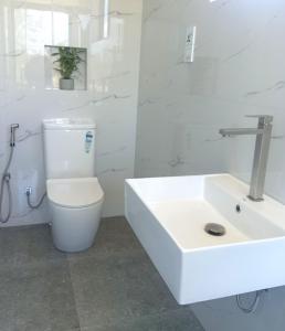 a white bathroom with a sink and a toilet at Pini Villa in Ampara +55 photos