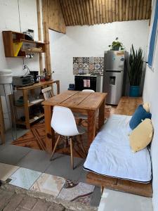 a kitchen with a wooden table and a refrigerator at El Chirris Tzanjay in San Juan La Laguna