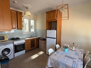 a kitchen with a table and a white refrigerator at Renas' Apartments in Chios island in Chios