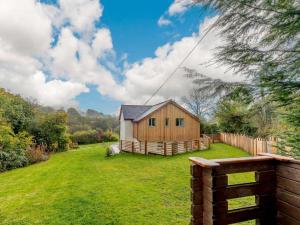 a wooden house in a yard with a fence at 3 Bed in Llandysul oc-90019 in Llandyssiliogogo