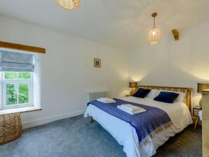 a bedroom with a bed and a window at 3 Bed in Llandysul oc-90019 in Llandyssiliogogo