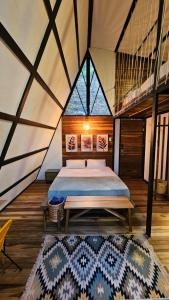 a bedroom in a tent with a bed and a rug at RESERVA BOWARA - Ecolodge in Pamplonita