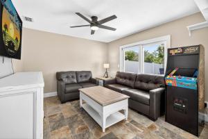 a living room with a couch and a refrigerator at Heated PoolFoosball,Pac Man Arcade, walk to beach in Clearwater Beach