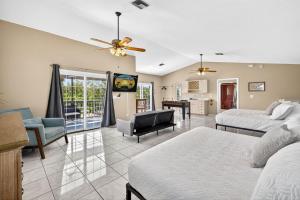 a living room with two beds and a tv at Heated PoolFoosball,Pac Man Arcade, walk to beach in Clearwater Beach
