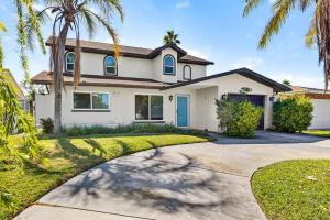 a house with palm trees and a driveway at Heated PoolFoosball,Pac Man Arcade, walk to beach in Clearwater Beach