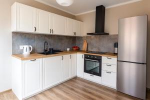 a kitchen with white cabinets and a refrigerator at Ceglana Przystań na Kaszubach in Załakowo