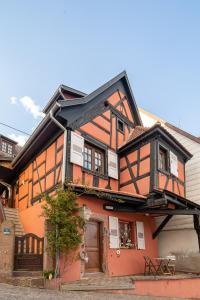 an orange and black house with a door at Au nid d'Alsace - SPA et sauna privé in Orschwiller