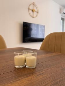two glasses of milk sitting on a wooden table at Inviti Apartments in Gjakove
