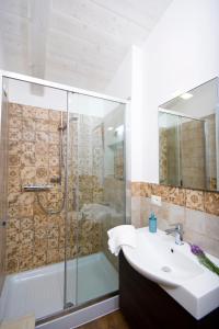 ein Bad mit einem Waschbecken und einer Glasdusche in der Unterkunft Bellafiora Affittacamere in Osimo
